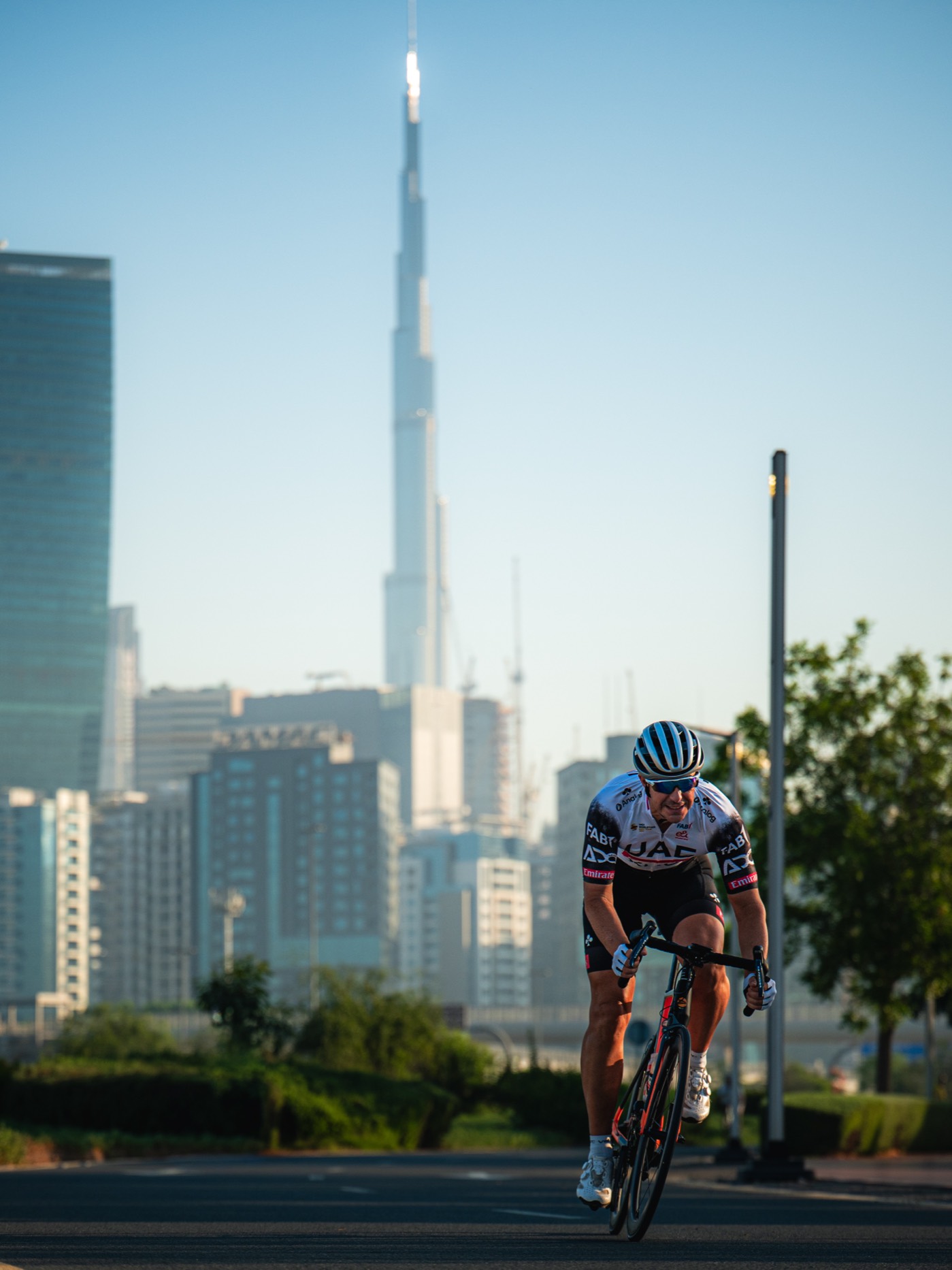 David Dudek auf dem Rennrad, im Hintergrund die Skyline von Dubai